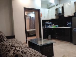 a living room with a couch and a kitchen at Parkway Apartments in Rawalpindi