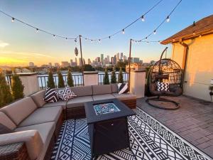 a rooftop patio with a couch and a table at Luxury Downtown Home w Rooftop Deck in the Skyline in Houston