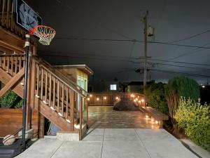 un aro de baloncesto en un porche por la noche en 9AM Check-in Coastal Getaway - Luxe Suite near Cliff, Lake & Local Shops, en Daly City