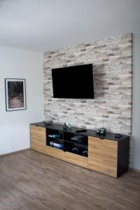 un soggiorno con TV su un muro di mattoni di Ferienwohnung Wolf a Veringenstadt Altre 13 foto