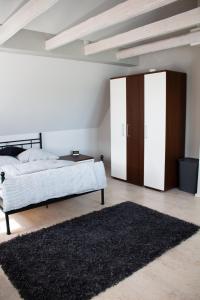 a bedroom with a bed and a wardrobe and a rug at Ferienwohnung Wolf in Veringenstadt