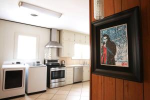 a kitchen with a painting of a woman on the wall at The Elvis House in Waco