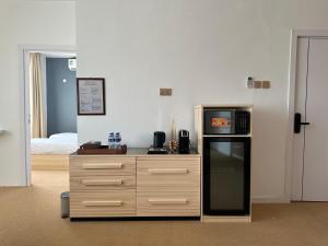 a kitchen with a counter with a microwave and a refrigerator at Al ATLAL apartment in Nizwa