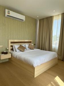 a bedroom with a large bed and a air conditioner at Al ATLAL apartment in Nizwa