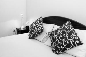 a bed with two black and white pillows on it at Villa Mare in Wadduwa