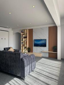 ein Wohnzimmer mit einem Sofa und einem TV in der Unterkunft Al ATLAL apartment in Nizwa