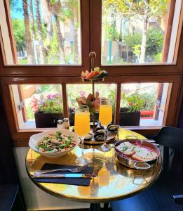a table with two plates of food and a window at The Rothschild Hotel - Tel Aviv's Finest in Tel Aviv