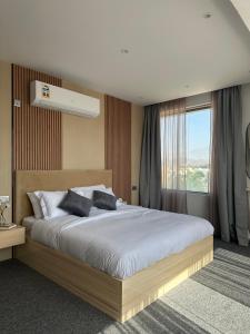 sypialnia z dużym łóżkiem i oknem w obiekcie Al ATLAL apartment w mieście Nizwa