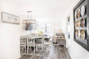 a dining room and living room with a table and chairs at Alexander Beach House Okanagan in Penticton