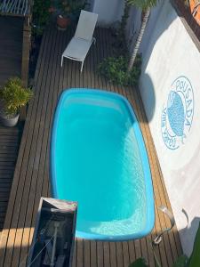 una vasca blu seduta su una terrazza accanto alla piscina di Pousada Villa Xaréu a Barra Grande