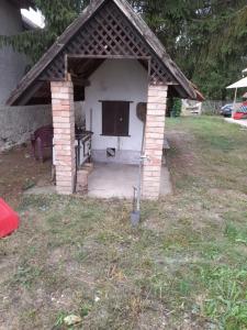 a small brick shelter with a table in a yard at Nyugalom Szigete in Demjén