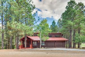 a house with a red roof in the woods at Cozy Angel Fire Escape with Golf Course Views! in Angel Fire