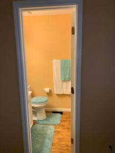 a bathroom with a toilet and towels on a wall at #Cozy2BrVilla in Lintonia - NearStone MTN Park in Lithonia