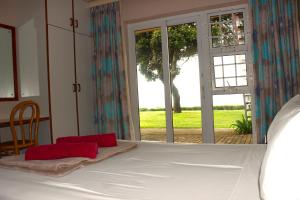 a bedroom with a bed and a large window at Anguna Holiday Flats in Margate