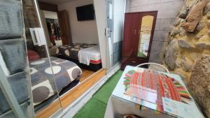 Cette chambre comprend 2 lits et une table. dans l'établissement Ccapac Inka Ollanta, à Ollantaytambo