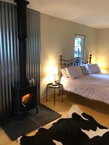 um quarto com uma cama e um fogão a lenha em Willow Lodge em Dublin