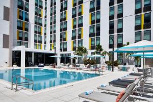 阿文圖納的住宿－Aloft Miami Aventura，一张酒店游泳池的图片,里面摆放着躺椅和遮阳伞