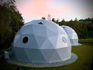 a group of three dome tents in a field at Poziom 713 in Trzebunia