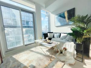 uma sala de estar com um sofá e uma mesa em INFIVILLA Amazing Penthouse Living in Sunrise- Breathtaking Skyline Lake View Downtown Toronto!A em Toronto