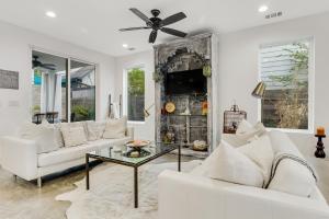 a living room with white furniture and a ceiling fan at EastSide Rooftop Oasis in Austin