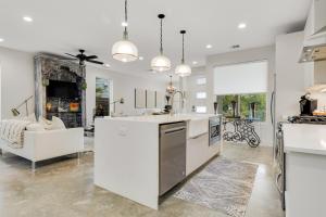 a kitchen with white appliances and a living room at EastSide Rooftop Oasis in Austin