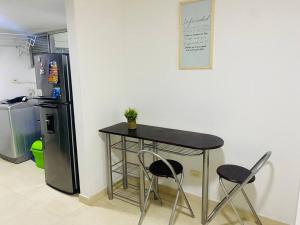 a table and two chairs next to a refrigerator at Hermoso lugar para descansar in Barranquilla