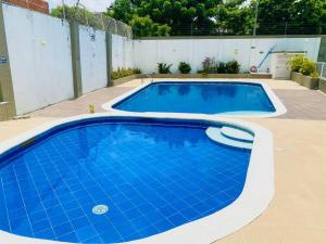 een zwembad in een achtertuin met een blauwe bij Hermoso lugar para descansar in Barranquilla