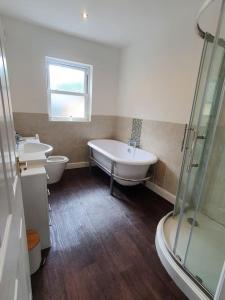 a bathroom with two sinks and a tub and a shower at Stable Mews: A Unique Natural Country Feel. in Hull