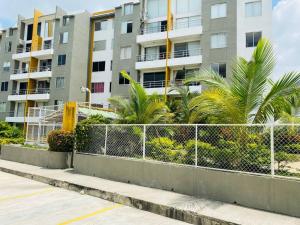een hek voor een gebouw met palmbomen bij Hermoso lugar para descansar in Barranquilla