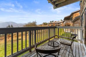 a deck with two chairs and a table and chairs at Sun Mountain Lodge in Winthrop