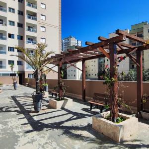 una pérgola de madera con un banco en un patio en Seu Ape em Taubaté, en Taubaté