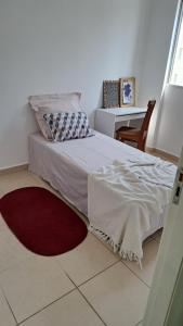 1 dormitorio con cama y alfombra roja en Seu Ape em Taubaté, en Taubaté