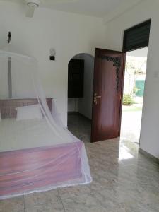 a bedroom with a bed and a wooden door at Villa Riverplace in Beruwala +32 photos