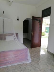 a bedroom with a bed and a wooden door at Villa Riverplace in Beruwala