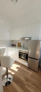 Una cocina con gabinetes blancos y un refrigerador de acero inoxidable. en Stilvolle Ferienwohnung Dresden, en Dresden