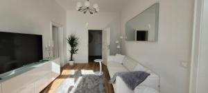 a living room with a couch and a flat screen tv at Stilvolle Ferienwohnung Dresden in Dresden