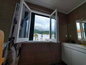 a bathroom with a window with a view of the ocean at Pousada da Vila in Vila Franca do Campo