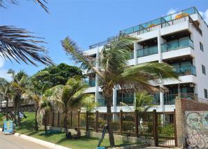 biały budynek z palmami przed nim w obiekcie Araça flat 308 - Lateral Vista Jardim w mieście Natal
