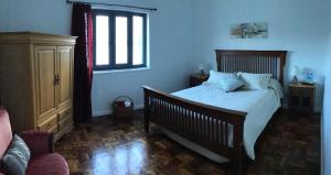a bedroom with a bed and a window and a chair at Pousada da Vila in Vila Franca do Campo