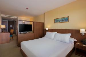 Habitación de hotel con cama y TV de pantalla plana. en Hotel Habitel Select en Bogotá