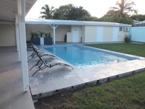 a swimming pool in the backyard of a house at Villa Créoléna in Anse-Bertrand