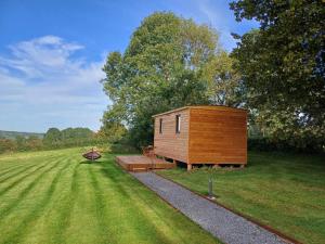 a small cabin in the middle of a grass field at La roulotte de Soiron in Pepinster