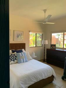 um quarto com uma cama branca e uma ventoinha de tecto em Condominio en Bahia Delfin em San Carlos
