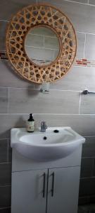 y baño con lavabo blanco y espejo. en Qunu Heritage Home - Mthatha, en Mthatha