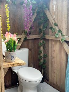 a bathroom with a toilet and flowers on the wall at Iguana Azul Pacific Paradise in Buenaventura