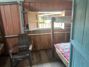 Cette chambre comprend une chaise, un lit et une fenêtre. dans l'établissement Iguana Azul Pacific Paradise, à Buenaventura