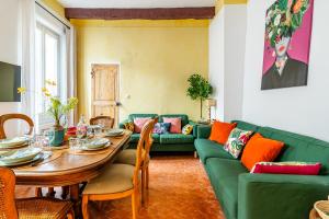 a living room with a green couch and a table at Casa Antoinette-Invitation vintage au-dessus du Vieux-Port in La Ciotat +22 photos