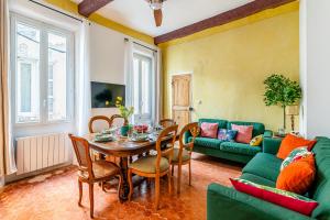 a living room with a table and a green couch at Casa Antoinette-Invitation vintage au-dessus du Vieux-Port in La Ciotat