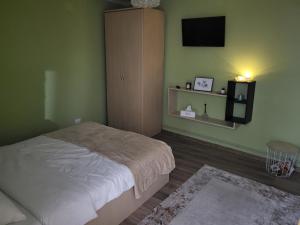 a bedroom with a bed and a flat screen tv at Casa La Balauri in Drobeta-Turnu Severin