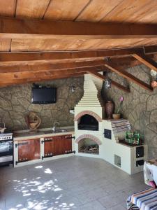 a kitchen with an outdoor oven with a stone wall at Casa La Balauri in Drobeta-Turnu Severin